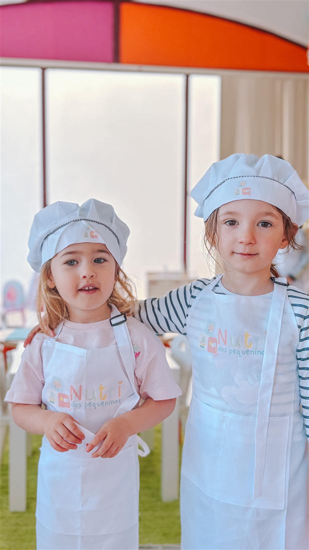 Dois pequenos chefs de avental e chapéu